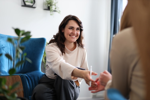 Professional woman reaching out to shake a client's hand