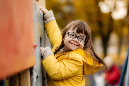 Young girl with Down Syndrome climbing