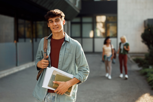 Young man standing outside of a university